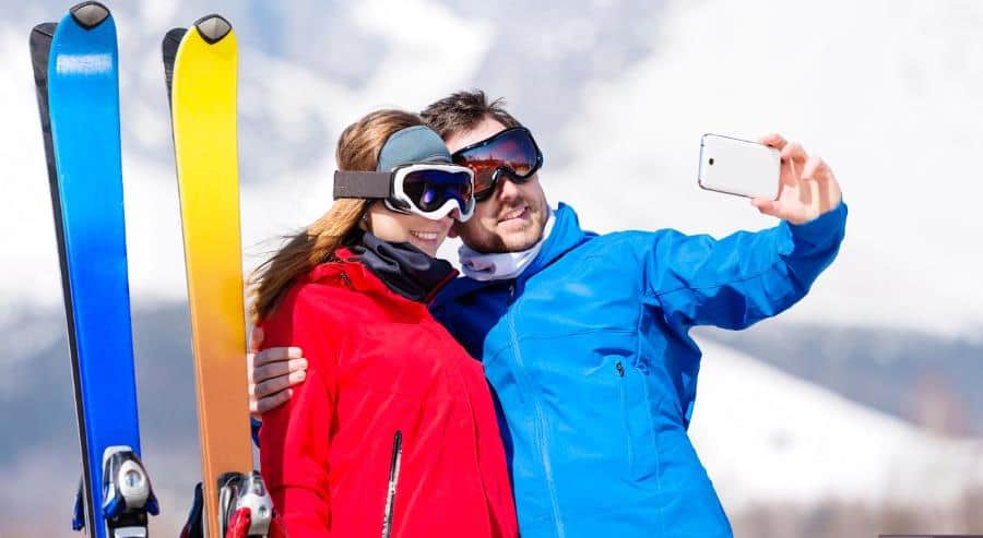 young couple skiing with their cell phone young couple skiing with their cell phone